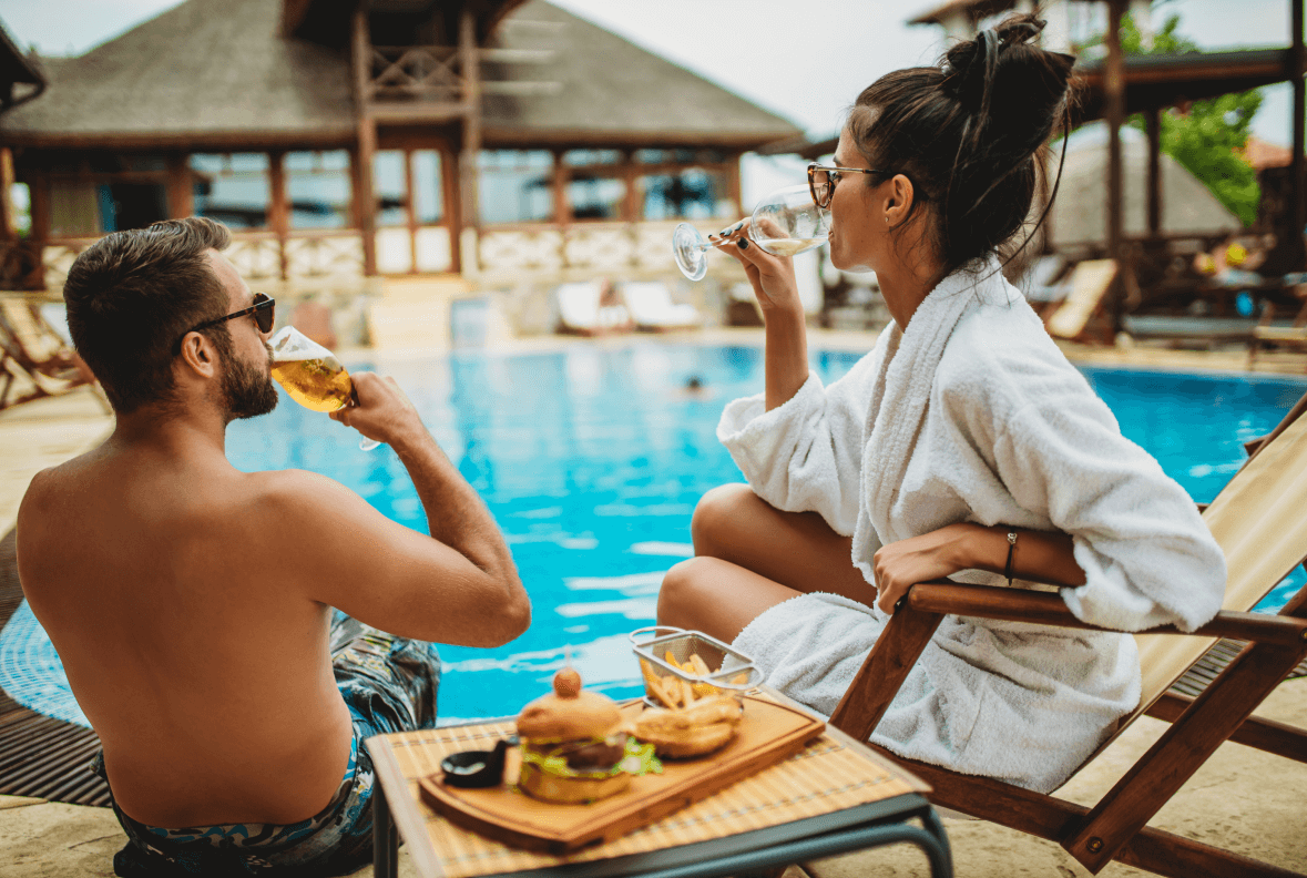 Young couple eating lunch by the pool